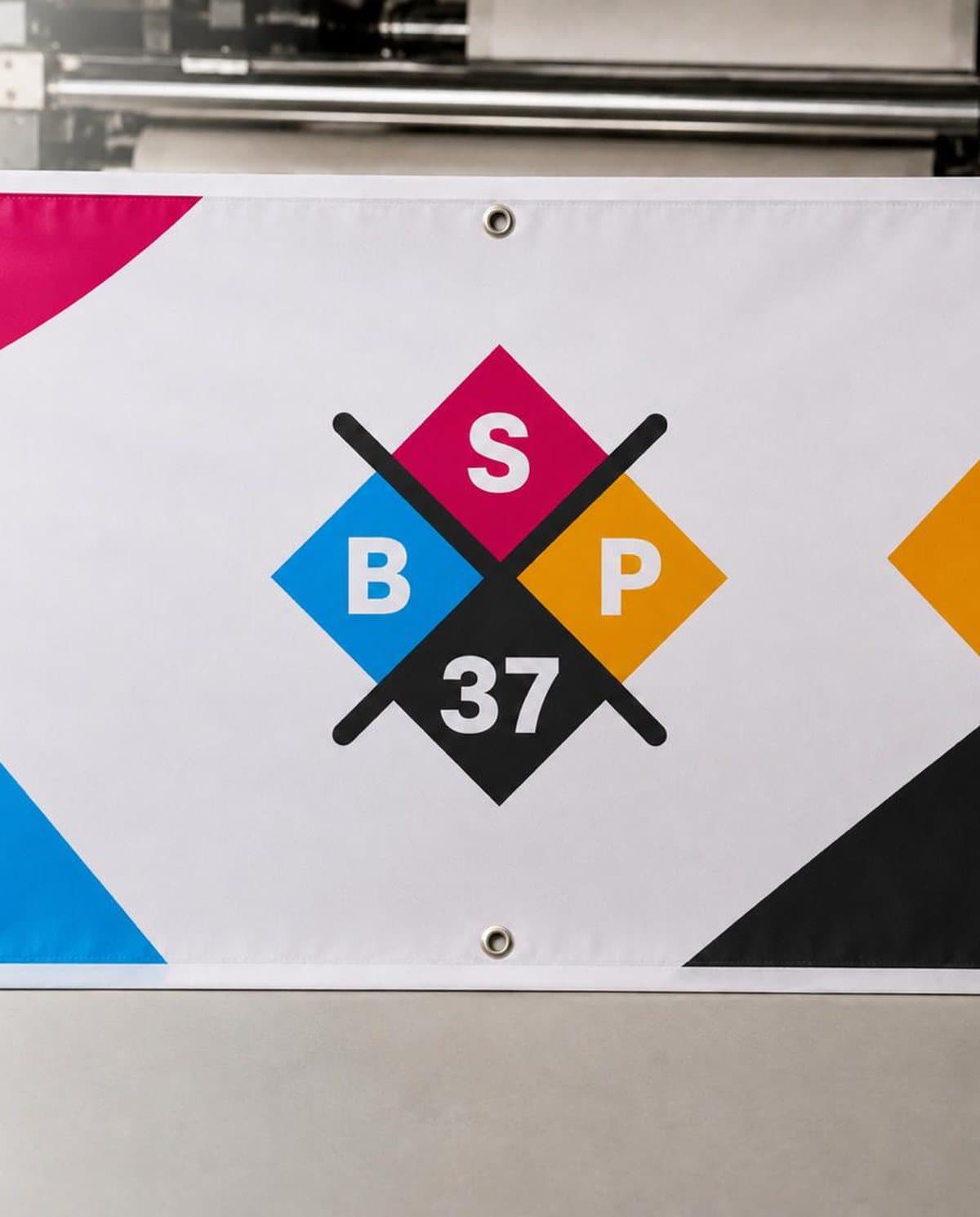 Banderole BSP37 œilletée en sortie d'impression dans l'atelier
