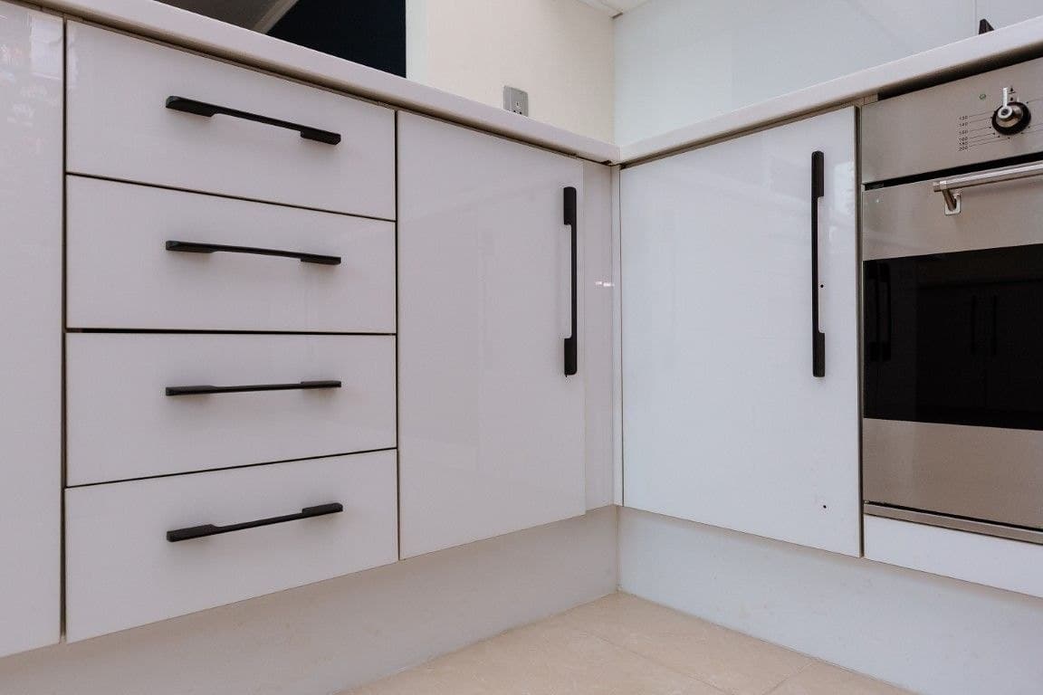 Cuisine avant rénovation, façades blanches brillantes