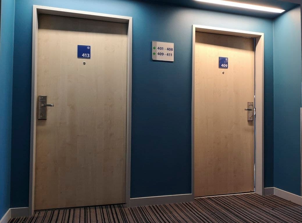 Portes de chambres d'hôtel avant rénovation, placage clair usé